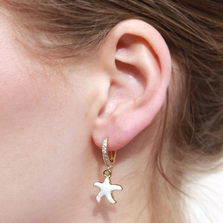 Boucles d'oreilles dorées étoile de mer blanc